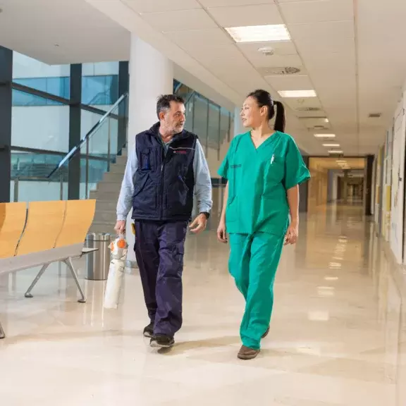 Un technicien et une médecin dans les couloirs d'un hôpital